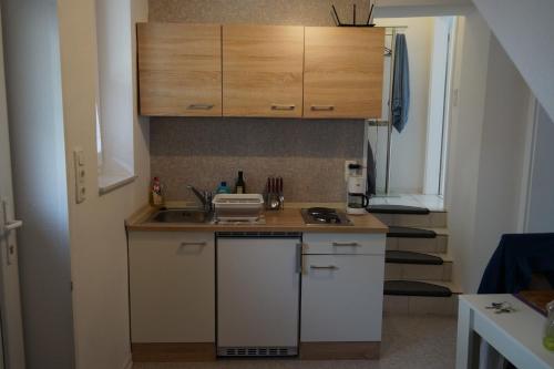 eine kleine Küche mit einem Waschbecken und Holzschränken in der Unterkunft 1 Zimmer Appartment in Springe