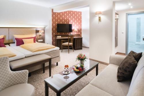 a hotel room with a bed and a couch at Schlosshotel Klaffenbach in Chemnitz