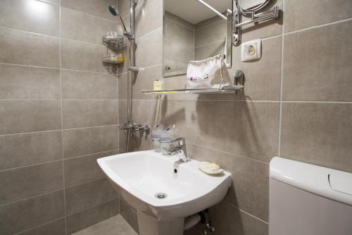 a small bathroom with a sink and a toilet at Hotel Yugoslavia in Nikšić