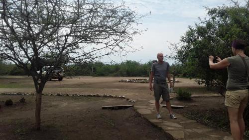 two men are standing next to a tree at Engiri Game Lodge and Campsite in Katunguru