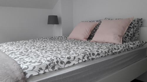 コウォブジェクにあるApartament Na Faliのベッド(白黒のシーツ、ピンクの枕付)