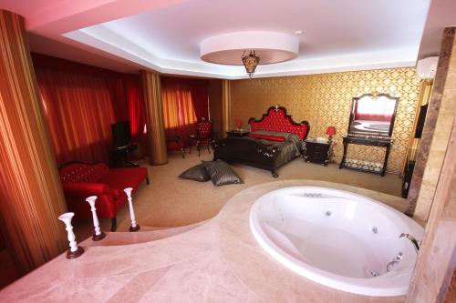 een grote badkamer met een bad en een slaapkamer bij Grand Corner Boutique Hotel in Izmir