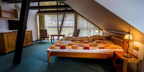 a bedroom with a bed with a checkered comforter at Hotel Trosky in Troskovice