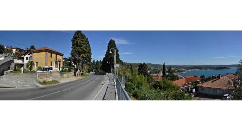 a view of a road with a house and a lake at Apartma Auriga in Portorož
