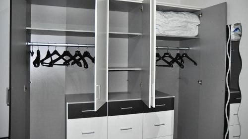 a walk in closet with white cabinets and hangers at Apartma Auriga in Portorož