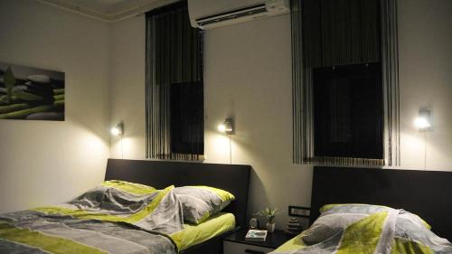 a bedroom with two beds and two windows at Apartma Auriga in Portorož