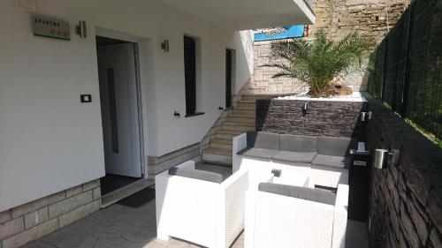 a group of white benches sitting outside of a building at Apartma Auriga in Portorož