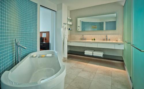 Hotel Arista في نابرفيل: حمام مع حوض ومغسلة ومرآة