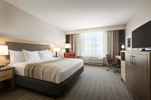 a hotel room with a bed and a desk at Country Inn & Suites by Radisson, New Braunfels, TX in New Braunfels
