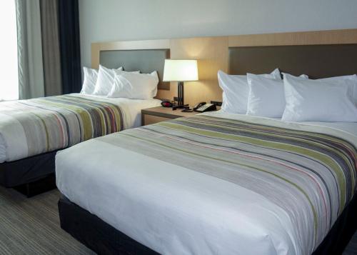 a hotel room with two beds and a telephone at Country Inn & Suites by Radisson, New Braunfels, TX in New Braunfels