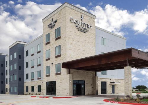 a large building with a clock on the front of it at Country Inn & Suites by Radisson, New Braunfels, TX in New Braunfels