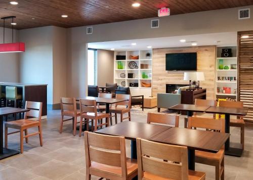 a restaurant with tables and chairs and a tv at Country Inn & Suites by Radisson, New Braunfels, TX in New Braunfels