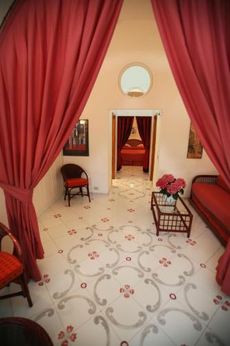 a living room with red curtains and a couch at Albergo Gatto Bianco in Capri