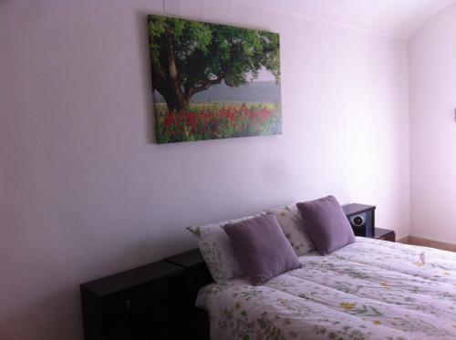- une chambre avec un lit et une peinture murale dans l'établissement Sa Domo Antiga, à Osilo