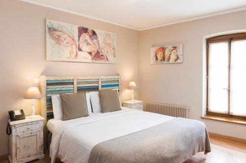 a bedroom with a large white bed and two windows at Auberge Communale de Carouge in Geneva