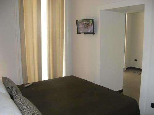 a room with a bed and a television on a wall at iBed Napoli B&B in Naples