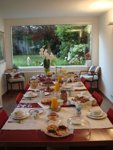 un lungo tavolo con cibo sopra con una grande finestra di B&B Maison Angélus a Saint Malo