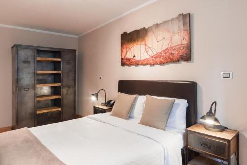 a bedroom with a large bed with white sheets at Auberge Communale de Carouge in Geneva