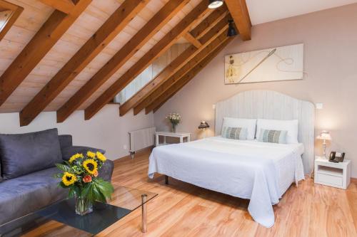 - une chambre avec un lit blanc et un canapé dans l'établissement Auberge Communale de Carouge, à Genève