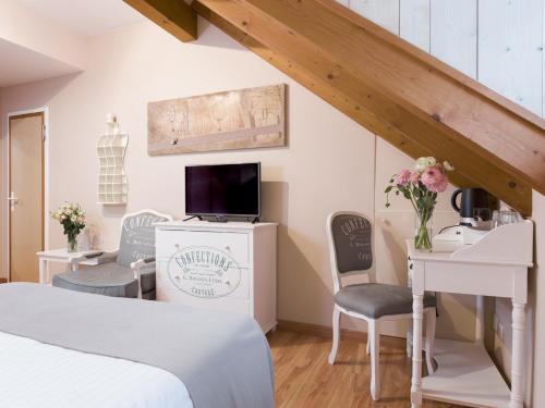 a bedroom with a bed and a desk and chairs at Auberge Communale de Carouge in Geneva