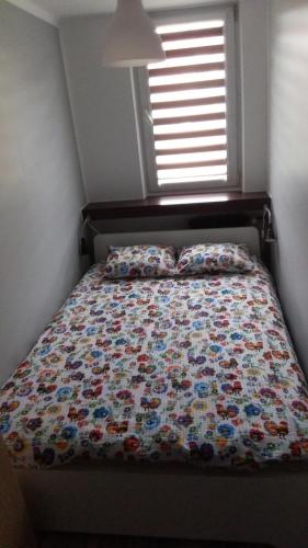 Una cama con edredón en un dormitorio en Blue Apartment Oświęcim en Oświęcim