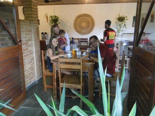 a group of people sitting at a table in a restaurant at Hotel Pousada Arco Iris in Barra de Santo Antônio