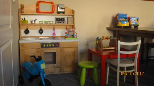 a toy kitchen with a table and a toy bike in it at Pension Žacléřský Medvěd in Žacléř