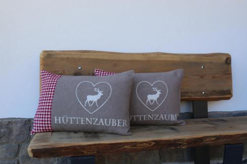 two pillows sitting on a wooden bench at Rufana Lodge in Bürserberg