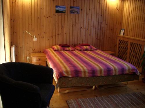 a bedroom with a bed and a chair in it at Männi Guesthouse in Haapsalu