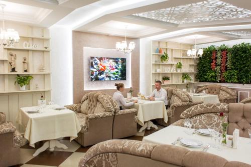 dos personas sentadas en mesas en un restaurante en Stanislavskiy Dvir, en Ivano-Frankivsk