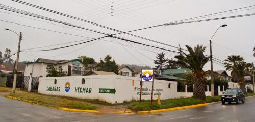 a car driving down a street next to a building at Cabañas Hecmar in Pichilemu