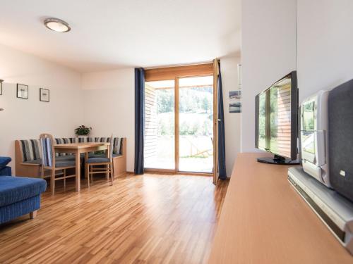 a living room with a television and a table with chairs at Gartenappartement Kirchdorf by A-Appartments in Brand