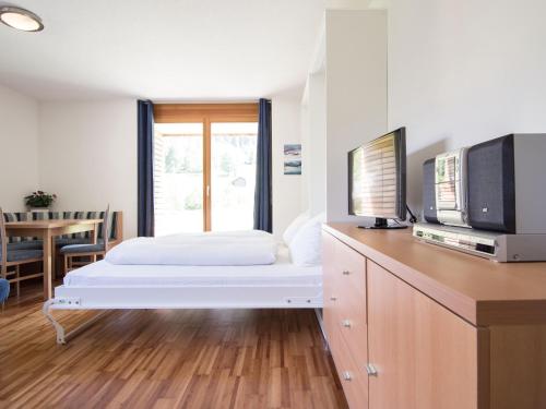 1 dormitorio con 1 cama, TV y mesa en Gartenappartement Kirchdorf by A-Appartments, en Brand