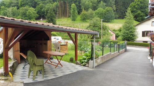 SondernachにあるSpacieux et confortables gîtes à proximité randonnées, lacs, ski natureのパティオ(テーブル、椅子、テーブル付)
