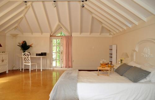 a bedroom with a large white bed and a table at Casita en Guamasa in Tacoronte