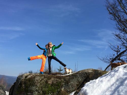 a woman standing on top of a rock with a dog at Apartmány Sportrelax in Albrechtice v Jizerských horách