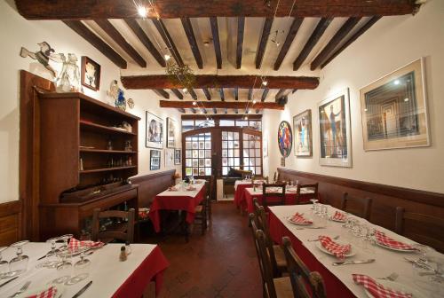 une salle à manger avec des tables et des nappes rouges dans l'établissement Hôtel Les Arcades, à Biot