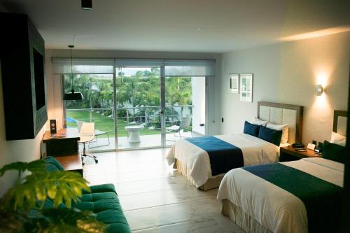 Habitación de hotel con 2 camas y sala de estar. en Hotel Aqua Spa & Resort, en Martínez de La Torre