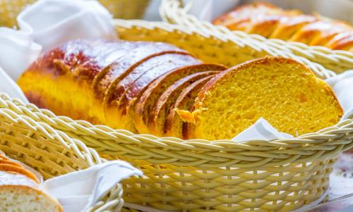 a basket filled with breads on a table at Pousada Suiça Mineira Centro in Monte Verde