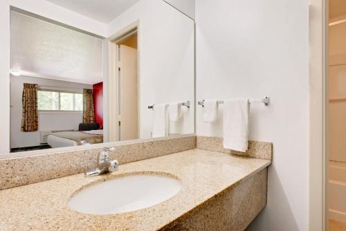 a bathroom with a sink and a mirror at Ramada by Wyndham Cleveland Airport West in Fairview Park