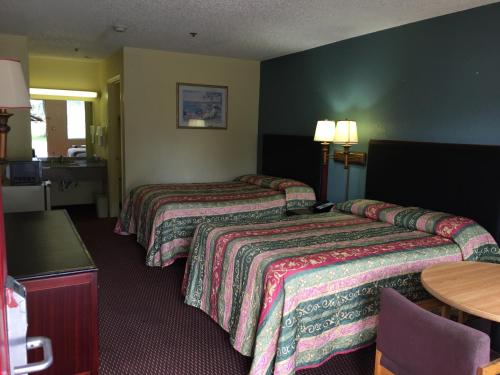 um quarto de hotel com duas camas e uma mesa em Relax Inn em Albany