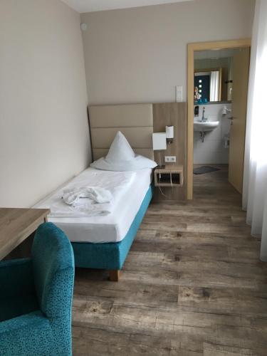a hotel room with a bed and a chair at Forsthaus am Möhnesee in Möhnesee