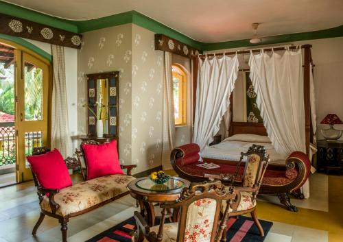 um quarto com uma cama, uma mesa e cadeiras em Casa Anjuna em Anjuna
