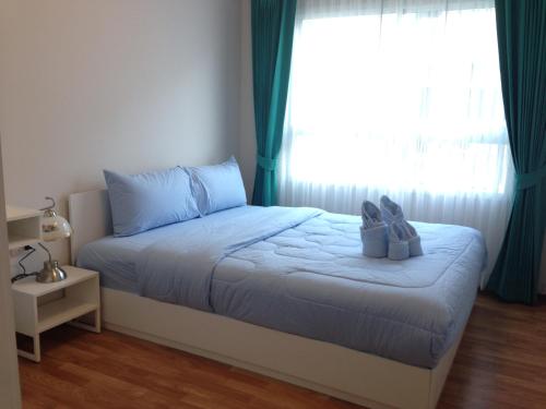 a bedroom with a bed with two shoes on it at The Trust Hua Hin Green and Blue Room Service in Hua Hin