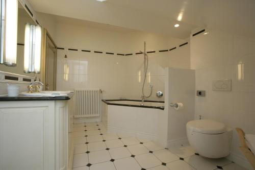 La salle de bains blanche est pourvue de toilettes et d'un lavabo. dans l'établissement L'An2, à Phalsbourg