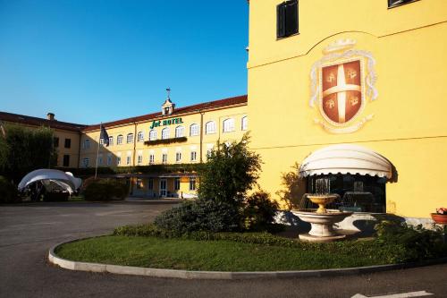 a yellow building with a fountain in front of it at Jet Hotel in Caselle Torinese