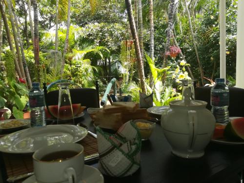 a table with cups and plates of food on it at City Paradise Dambulla in Dambulla