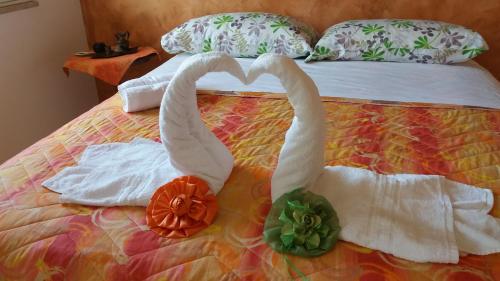 two swans made out of towels on a bed at Colomba Bianca in Marsala
