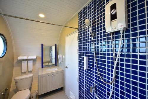 a bathroom with a toilet and a blue tiled wall at Krabi Boat Lagoon Resort in Krabi town