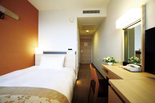 a hotel room with a bed and a desk at Karasuma Kyoto Hotel in Kyoto